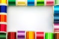 Frame made of spools with color sewing threads on white background, top view. Free space for text Royalty Free Stock Photo