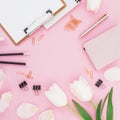 Frame made of tulips flowers with clipboard, clips and dairy on pink background. Blogger concept. Flat lay, top view. Royalty Free Stock Photo