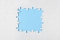 Frame made with white puzzle pieces on blue background, top view. Space for text Royalty Free Stock Photo