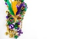 Frame of Mardi Gras mask and beads isolated on white background. Royalty Free Stock Photo