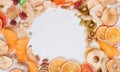 Frame of mixed dried fruit and vegetable chips, candied pumpkin slices, nuts and seeds on white marble background Royalty Free Stock Photo