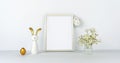 Frame mock up for your text. Eggs and fun rabbit with golden ears. Flowers on background of white table and wall Royalty Free Stock Photo