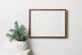 Frame mockup with copy space for artwork, photo or print presentation. White wall interior with christmas tree. Royalty Free Stock Photo