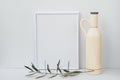 Frame mockup on white background, ceramic bottle, olive tree branch, clean minimalist styled image Royalty Free Stock Photo