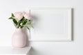 Frame mockup on white wall with pink peony flowers, mockup for artwork, photo or print