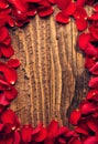 Frame of petals of red roses on wooden backdrop Royalty Free Stock Photo