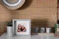 Frame with photo of elderly woman and her granddaughter on white table indoors