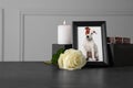 Frame with picture of dog, collar, burning candle and rose on black table, space for text. Pet funeral Royalty Free Stock Photo