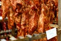 Frame picture of a pieces of smoked spicy meat, hung on hooks and arranged on a stand. Royalty Free Stock Photo