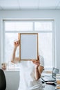 Frame picture, poster, diploma, certificate mockup in female hands. Faceless woman holding empty blank wooden photo Royalty Free Stock Photo