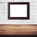 Frame picture on white brick wall and wood table background Royalty Free Stock Photo