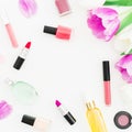 Frame of pink flowers and cosmetics, lipstick, nail polish on white background. Top view. Flat lay feminine desk. Royalty Free Stock Photo