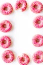 Frame of pink glazed donutes with sprinkles, top view