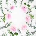 Frame of pink roses flowers and eucalyptus branches on white background. Flat lay, top view. Royalty Free Stock Photo