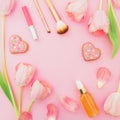 Frame with pink tulips flowers and cosmetics, cookies on pink pastel background. Flat lay, top view with copy space. Spring time Royalty Free Stock Photo