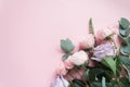 Frame of purple and pink roses, white Lisianthus and different flowers on pink background.