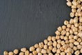 Frame of raw chickpeas on black slate dish, flat food background