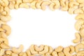 Frame of raw, organic, whole cashew nut kernels over white