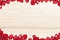 The frame of red rose petals with a wooden table background Royalty Free Stock Photo