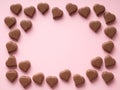 Chocolate hearts confections frame on pink, copy space Royalty Free Stock Photo