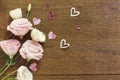 Frame Roses and paper hearts over wooden texture