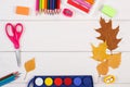 Frame of school accessories and autumnal leaves on white boards, back to school concept Royalty Free Stock Photo