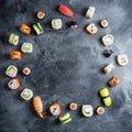 Frame with set of Japanese food on dark background. Sushi rolls, nigiri, raw salmon steak, rice and avocado. Flat lay. Top view Royalty Free Stock Photo