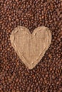 Frame in the shape of heart made of burlap with coffee beans Royalty Free Stock Photo