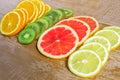 Frame with slice of oranges, lemons, kiwi, grapefruit pattern  on wooden background. copy space Royalty Free Stock Photo