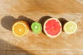 Frame with slice of oranges, lemons, kiwi, grapefruit pattern  on wooden background. Flat lay, top view with copy space Royalty Free Stock Photo