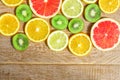 Frame with slice of oranges, lemons, kiwi, grapefruit pattern  on wooden background. Flat lay, top view with copy space Royalty Free Stock Photo