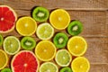 Frame with slices of oranges, lemons, kiwi, grapefruit pattern on wooden background. Copy space Royalty Free Stock Photo