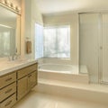 Frame Square Bathtub and double vanity unit inside the well lighted bathroom of a home Royalty Free Stock Photo