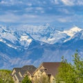 Frame Frame Square Houses and lush green trees with snow capped mountain in the background