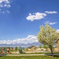 Frame Square Panorama of park and houses with view of lake and mountain under cloudy sky Royalty Free Stock Photo