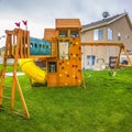 Frame Square Playground structure with slide swings playhouse tower and climbing wall Royalty Free Stock Photo