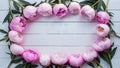 Frame Stunning pink peonies arranged on white rustic wooden background