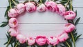 Frame Stunning pink peonies arranged on white rustic wooden background