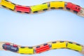 Frame for text made of multicolor kids train cars bricks on wooden railway on blue background. Copyspase. top view. flat lay.