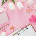 Frame with tulips flower, mug of coffee, clipboard, clips and glasses on pink background. Blogger concept. Flat lay, top view.