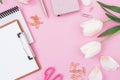 Frame with tulips flowers, clipboard, clips and scissors on pink background. Blogger concept. Flat lay, top view. Royalty Free Stock Photo