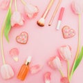 Frame with tulips flowers and cosmetics, cookies on pink pastel background. Flat lay, top view. Spring time background. Royalty Free Stock Photo