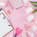 Frame with tulips flowers, mug of coffee, clipboard, clips and glasses on pink background. Blogger concept with copy space. Flat l Royalty Free Stock Photo