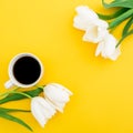 Frame of tulips flowers with mug of coffee on yellow background. Floral concept. Flat lay, top view. Royalty Free Stock Photo