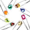 Frame of tweezers with different shiny gemstones on background