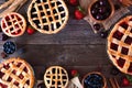 Frame of a variety of homemade fruit pies over a rustic wood background