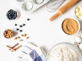 Frame of various baking ingredients - flour, eggs, sugar, butter, fresh blueberries, nuts, kitchen utensils and cupcake baking Royalty Free Stock Photo