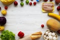 Frame of various healthy food on white wooden background. Fresh fruits, vegetables, greens, meat, milk. Top view, overhead, from a Royalty Free Stock Photo