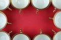 Frame of vintage tea cups with gilding on a red background top view