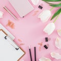 Frame with white flowers, clipboard, clips and pencil on pink background. Blogger concept with copy space. Flat lay, top view. Royalty Free Stock Photo